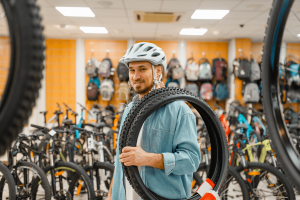 man-in-cycling-helmet-holds-bicycle